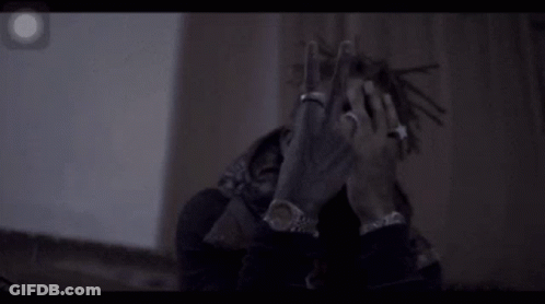 A Man With Dreadlocks And A Ring On His Finger Is Making A Peace Sign . GIF