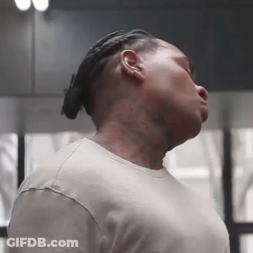 A Man With Dreadlocks And A Tattoo On His Neck Is Looking Down GIF