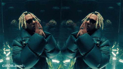 A Man With Dreadlocks And Sunglasses Is Standing In Front Of A Mirror GIF