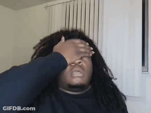 A Man With Dreadlocks Has His Hand On His Face GIF