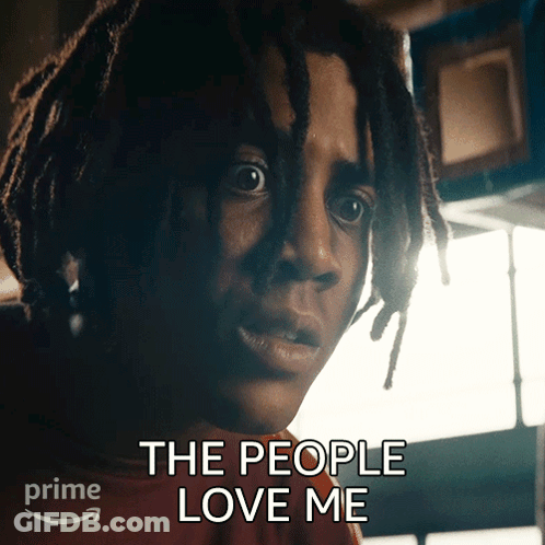 A Man With Dreadlocks Has The Words " The People Love Me " Above His Head GIF