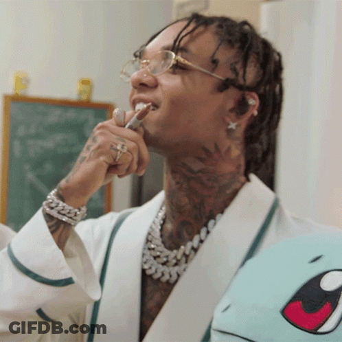 A Man With Dreadlocks Is Brushing His Teeth While Wearing Glasses GIF