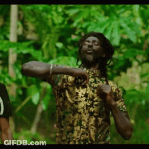 A Man With Dreadlocks Is Dancing In The Jungle . GIF