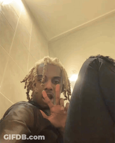 A Man With Dreadlocks Is Giving The Peace Sign GIF