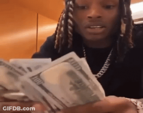 A Man With Dreadlocks Is Holding A Bunch Of Money . GIF
