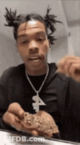 A Man With Dreadlocks Is Holding A Piece Of Marijuana In His Hands . GIF