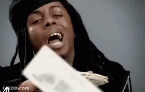 A Man With Dreadlocks Is Holding A Stack Of Money In His Hand And Making A Funny Face . GIF