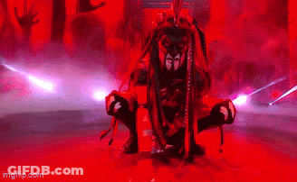 A Man With Dreadlocks Is Holding A Sword In Front Of A Crowd Of People In Red Lights . GIF