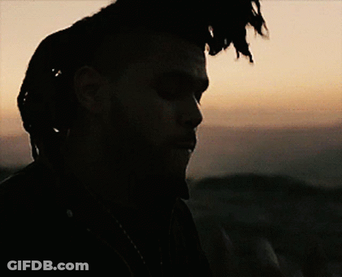 A Man With Dreadlocks Is Looking At A Cell Phone GIF
