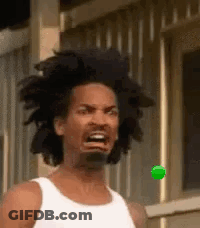 A Man With Dreadlocks Is Making A Funny Face While Looking At A Green Ball . GIF