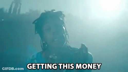 A Man With Dreadlocks Is Singing Into A Microphone With The Words Getting This Money Above Him GIF