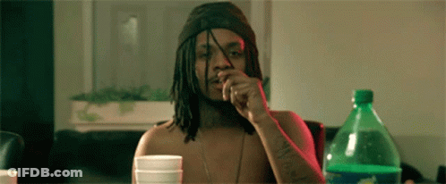 A Man With Dreadlocks Is Sitting At A Table With A Sprite Bottle In Front Of Him GIF