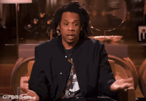A Man With Dreadlocks Is Sitting In A Chair Talking GIF