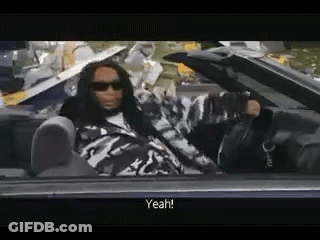 A Man With Dreadlocks Is Sitting In A Convertible Car And Talking . GIF