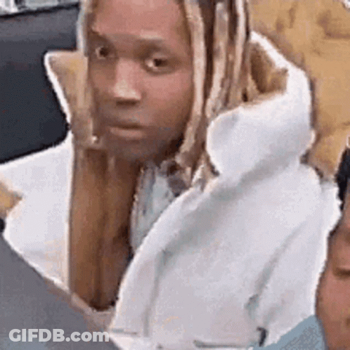 A Man With Dreadlocks Is Sitting Next To Another Man In A White Coat . GIF