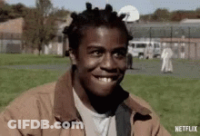 A Man With Dreadlocks Is Smiling In A Park With A Netflix Logo In The Corner GIF