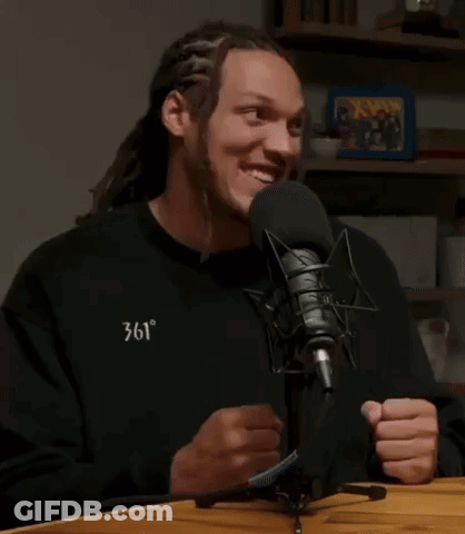 A Man With Dreadlocks Is Smiling In Front Of A Microphone With The Words It 'S Cam Johnson Above Him GIF
