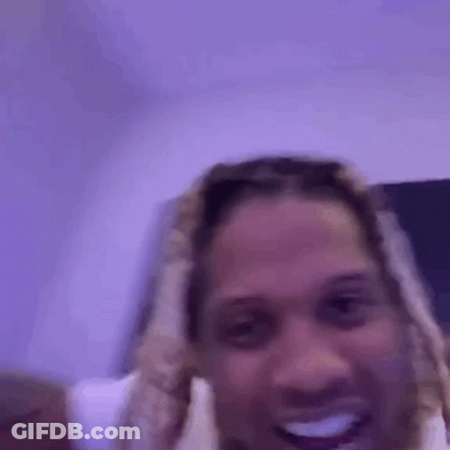 A Man With Dreadlocks Is Smiling While Holding A Purple Light Up Guitar . GIF