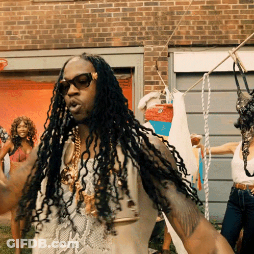 A Man With Dreadlocks Is Standing In Front Of A Clothes Line GIF