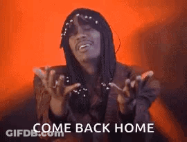 A Man With Dreadlocks Is Standing In Front Of A Red Background And Says `` Come Back Home '' With His Hands Outstretched GIF