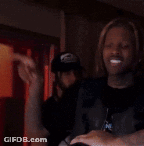 A Man With Dreadlocks Is Standing Next To A Woman In A Dark Room . GIF