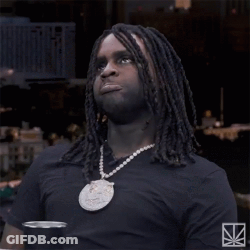 A Man With Dreadlocks Is Wearing A Black Shirt And A Necklace With A Pendant That Says ' N4 ' GIF
