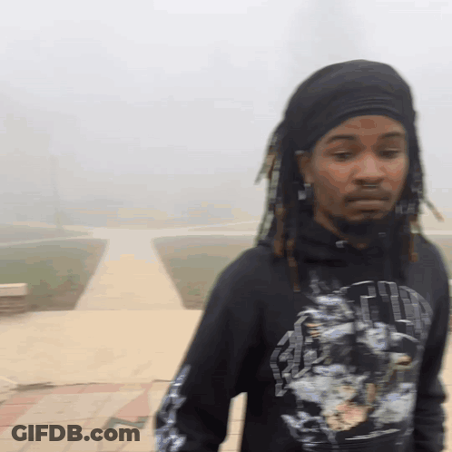 A Man With Dreadlocks Is Wearing A Black Shirt That Says ' Faith ' GIF