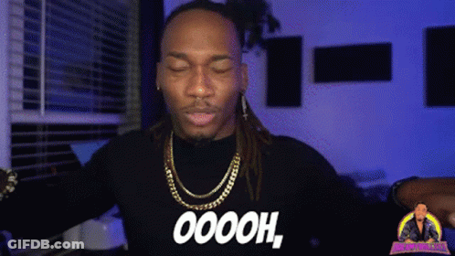 A Man With Dreadlocks Is Wearing A Black Shirt That Says Oooh GIF