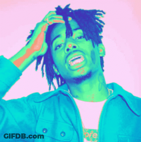A Man With Dreadlocks Is Wearing A Blue Jacket And A White T-Shirt GIF