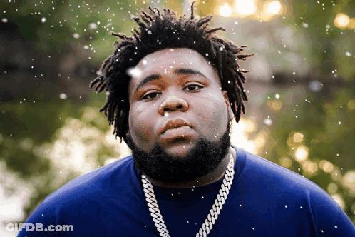 A Man With Dreadlocks Is Wearing A Blue Shirt GIF