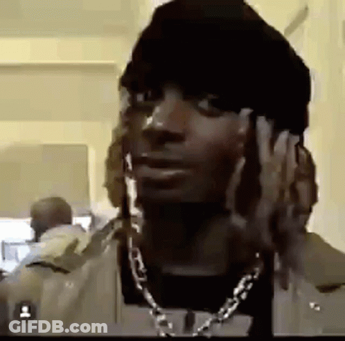 A Man With Dreadlocks Is Wearing A Hat And A Necklace . GIF