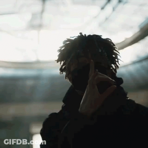 A Man With Dreadlocks Is Wearing A Mask And Making A Peace Sign With His Hands GIF