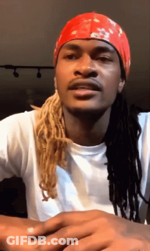 A Man With Dreadlocks Is Wearing A Red Headband GIF