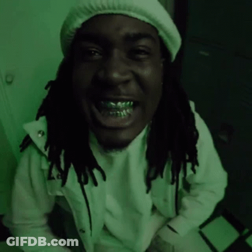 A Man With Dreadlocks Is Wearing A White Hat And A White Jacket And Is Smiling . GIF