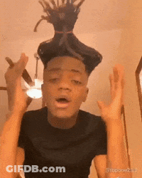 A Man With Dreadlocks On His Head Is Making A Funny Face With His Hands In The Air . GIF