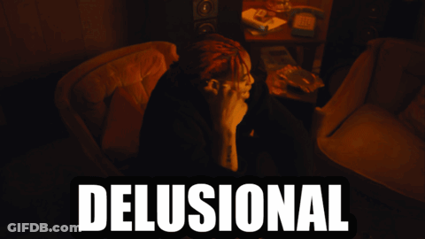 A Man With Dreadlocks Sits In A Chair With The Word Delusional Written Above Him GIF