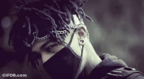 A Man With Dreadlocks Wearing A Black Mask And Chains Around His Head GIF