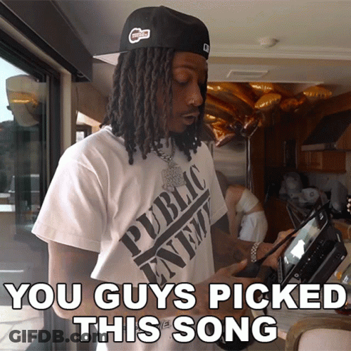 A Man With Dreadlocks Wearing A Public Enemy Shirt GIF