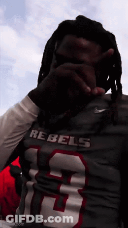 A Man With Dreadlocks Wearing A Rebels Jersey GIF