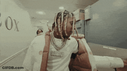 A Man With Dreadlocks Wearing A Shirt That Says Neo GIF