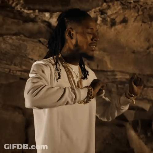A Man With Dreadlocks Wearing A White Sweater And Gold Chains GIF