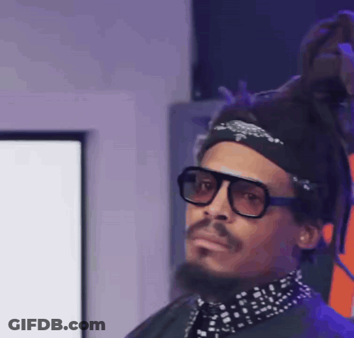 A Man With Dreadlocks Wearing Sunglasses And A Bandana GIF