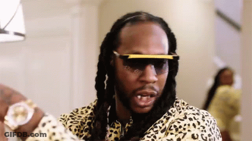 A Man With Dreadlocks Wearing Sunglasses And A Leopard Print Shirt . GIF