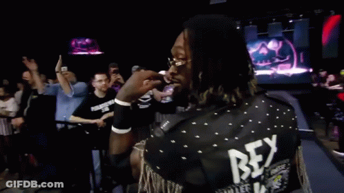 A Man With Dreadlocks Wearing Sunglasses Is Smiling In Front Of A Crowd . GIF