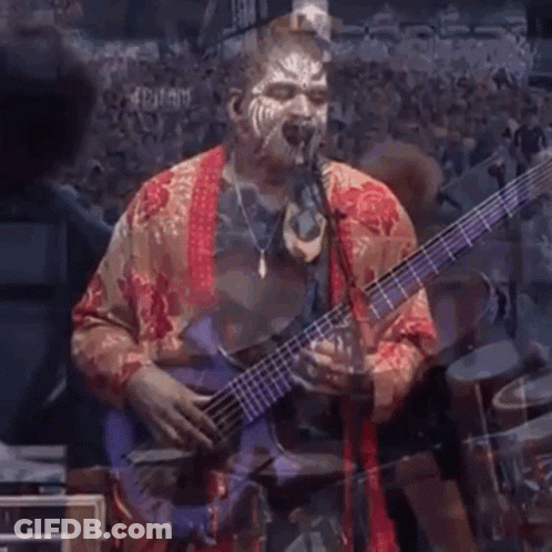 A Man With Face Paint Playing A Bass Guitar GIF