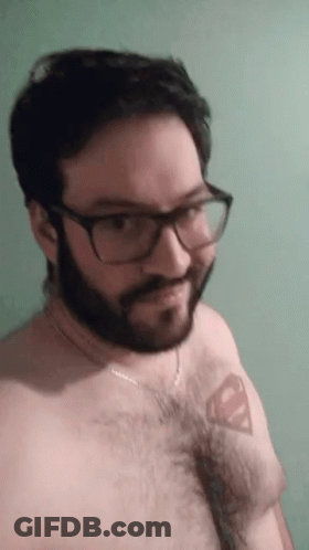 A Man With Glasses And A Beard Has A Superman Tattoo On His Chest GIF