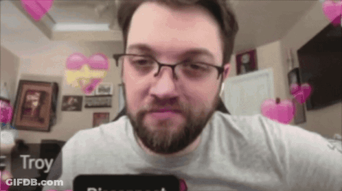 A Man With Glasses And A Beard Has Troy Written On His Phone Screen GIF