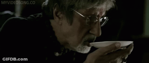 A Man With Glasses And A Beard Is Drinking From A White Bowl With The Words Myvideosong.co Written On The Bottom GIF