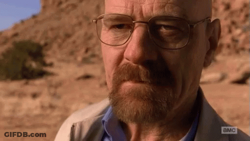 A Man With Glasses And A Beard Is Looking At The Camera With A Cliff In The Background . GIF