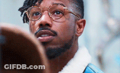 A Man With Glasses And A Beard Is Looking Up At Something . GIF